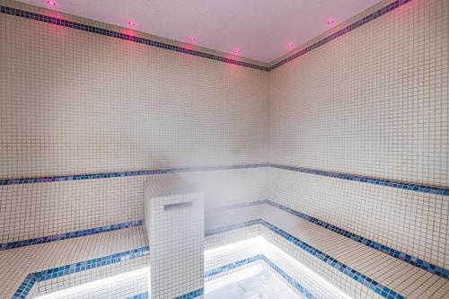 a bathroom with a tub with blue and white tiles at Harbour Hotel & Spa Southampton in Southampton