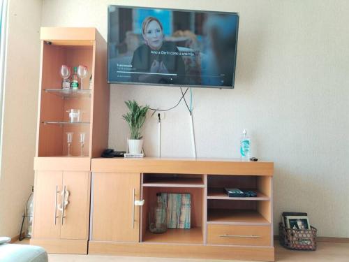 una TV a schermo piatto in cima a un centro di intrattenimento in legno di Bello departamento en altozano a Tacna