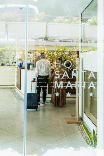 a man walking with a suitcase in a store window at Grand Hotel Santa Maria in Santa Maria di Castellabate