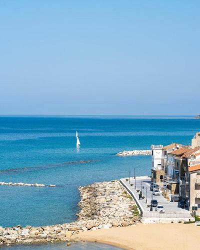 a sail boat in the water near a beach at Grand Hotel Santa Maria in Santa Maria di Castellabate