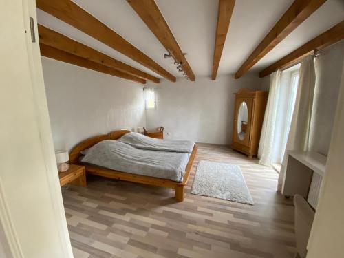 a bedroom with a bed and a wooden floor at Ferienwohnung mit schöner Terrasse. in Ellerstadt