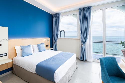 a hotel room with a bed and a large window at Grand Hotel Santa Maria in Santa Maria di Castellabate