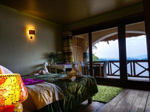 Birdnest Resort في Kabale: غرفة نوم بسرير يستلقي عليه اشخاص
