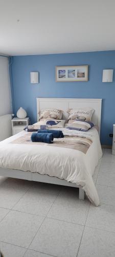 sypialnia z dużym białym łóżkiem z niebieskimi ścianami w obiekcie Mitten im Dorf und doch im Grünen w mieście Montblanc