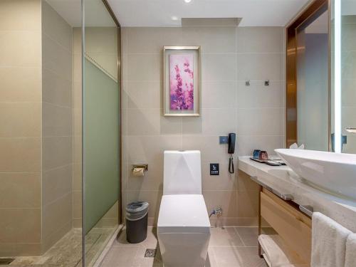 uma casa de banho com um lavatório e uma cabina de duche em vidro. em Lavande Hotel Guangzhou Shatai South Road Tianpingjia Metro Station em Guangzhou