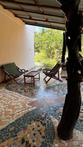 a patio with two lounge chairs and a table at Lodge Jamarek in Kafountine
