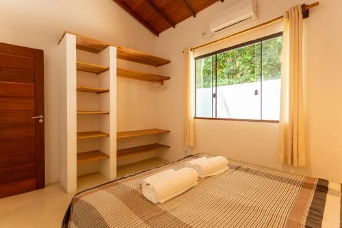a bedroom with a bed and a window at Vila Marina in Arraial d'Ajuda