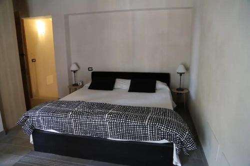 ein Schlafzimmer mit einem schwarzen und weißen Bett mit zwei Lampen in der Unterkunft La Corte dei Grappoli in Viarigi