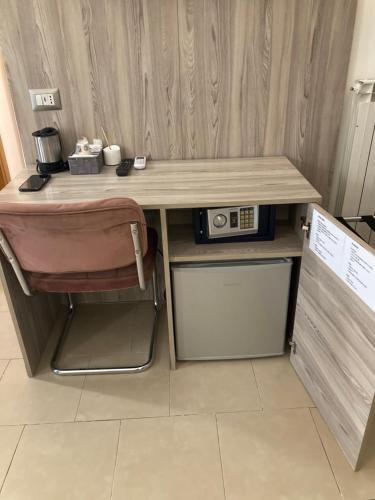 a desk with a microwave and a chair in a room at 4STANZE in Naples