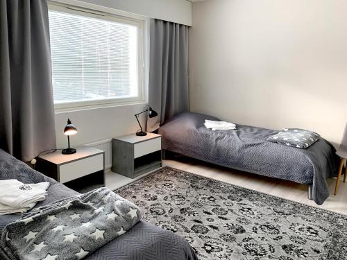 a bedroom with two beds and a window at Apartment Ryti in Kokkola