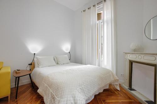a white bedroom with a bed and a fireplace at MEZZANINE ORANGE in Madrid