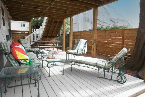 una terrazza con sedie, tavoli e recinzione di 508 A The Shore Break Cottage a Virginia Beach
