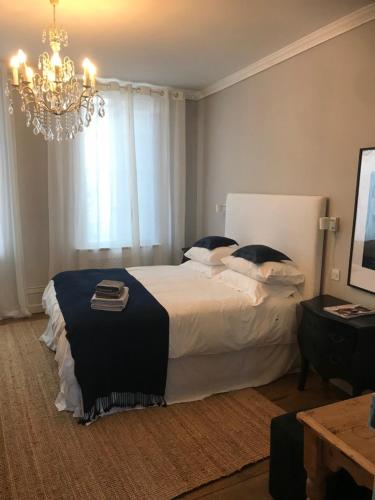 ein Schlafzimmer mit einem großen Bett und einem Kronleuchter in der Unterkunft The Apartment in Saint-Jean-dʼAngély
