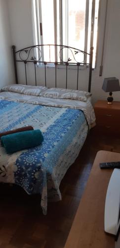 a bedroom with a bed with a blue quilt on it at Habitación LCV in Madrid