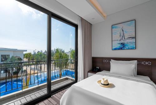 sypialnia z łóżkiem i dużym oknem w obiekcie Hoang Yen Boutique Hotel w mieście Dien Ban