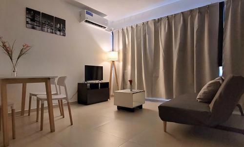 un soggiorno con divano, tavolo e TV di Pacifico Apartment a Buenos Aires