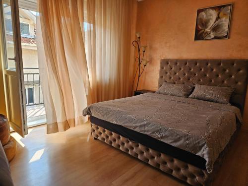 a bedroom with a bed in a room with a window at Apartments "Villa Miona" in Belgrade