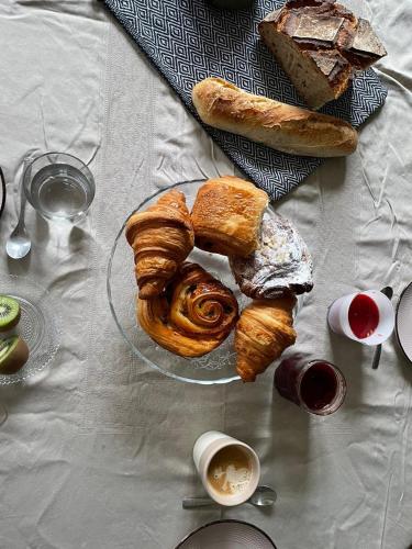 - une table avec un plateau de viennoiseries et de pain dans l'établissement Bed and Breakfast 2 chambres, 1 salle d'eau - Centre Versailles, à Versailles
