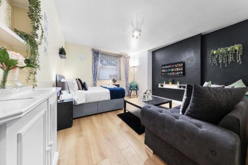 a bedroom with a bed and a couch in a room at Heart of London Luxury, 1 Min Walk from Paddington Station, Beautiful Apartment with Smart TV in London