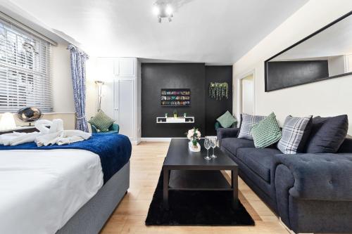 a living room with a bed and a couch at Heart of London Luxury, 1 Min Walk from Paddington Station, Beautiful Apartment with Smart TV in London