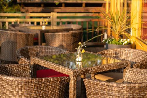 a wicker table and chairs on a patio at Seehotel Urban in Bodensdorf