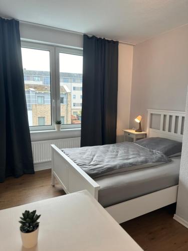 een slaapkamer met een bed en een groot raam bij Ferienwohnung Hansetraum Lübeck in Lübeck