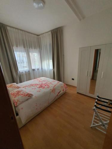 a bedroom with a bed and a window and a chair at Casa di Fati in Mestre