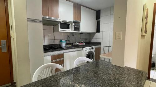 una cucina con armadi bianchi e piano di lavoro di Apartamento 3 Quartos Thermas Paradise a Rio Quente