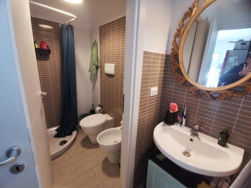 ein Badezimmer mit Waschbecken, Toilette und Spiegel in der Unterkunft Villetta Luxury Lunady vicino al mare in Marina di Ragusa