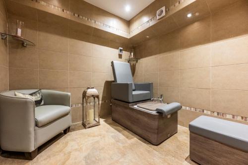 um salão com um lavatório e uma cadeira num quarto em The Marcliffe Hotel and Spa em Aberdeen