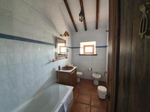 a bathroom with a tub and a toilet and a sink at Molino de Las Pilas - Ecoturismo - Caminito del Rey in Teba