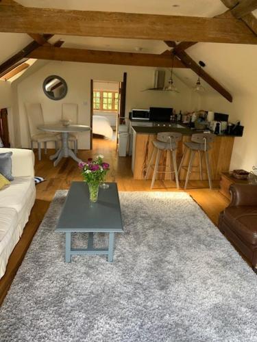 a living room with a couch and a table with flowers on it at Beautiful converted Coach house for two in Hoptonheath