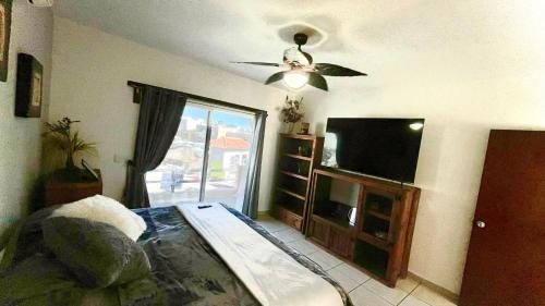 uma sala de estar com uma ventoinha de tecto e uma televisão de ecrã plano em Casa bella Loma encantada em San José del Cabo