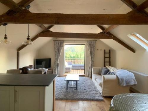 a living room with a couch and a table at Beautiful converted Coach house for two in Hoptonheath