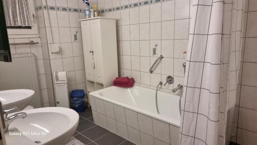 a bathroom with a tub and a toilet and a sink at Haus Zeller in Klettgau