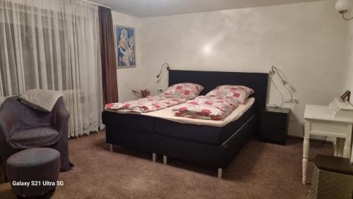 a small bedroom with a bed and a chair at Haus Zeller in Klettgau