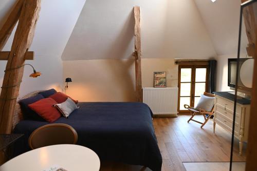 a bedroom with a bed and a table at une oasis dans le perche in Rémalard en Perche