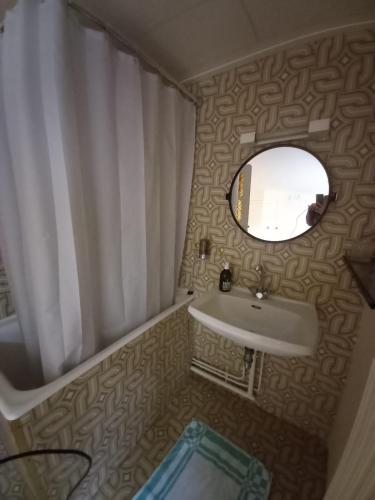 a small bathroom with a sink and a mirror at Maison auvergnate rénovée et confortable in Murat