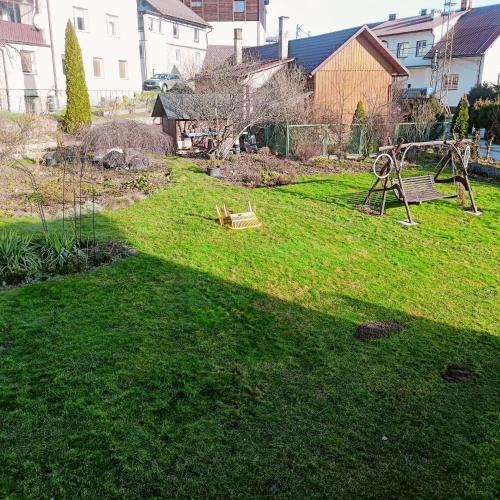 a yard with a playground in the grass at Pokoje u Danuty in Piwniczna-Zdroj