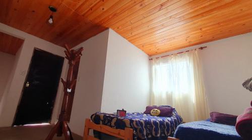 - une chambre avec un plafond en bois et une fenêtre dans l'établissement Casa Santa Clara, à Santa Clara del Mar