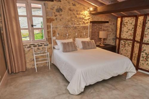 1 dormitorio con cama blanca y ventana en Alojamiento y Visita a Bodega Miradorio Incluida, en Casasola
