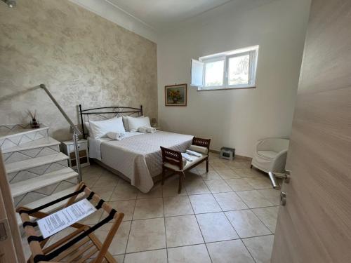 a bedroom with a bed and a chair and a window at La Terrazza sul Mare in Capri