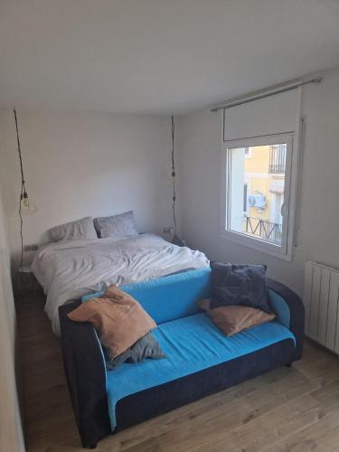 ein Schlafzimmer mit einem Bett und einem blauen Sofa in der Unterkunft Cozy sunny apartment in the heart of Barcelona in Barcelona