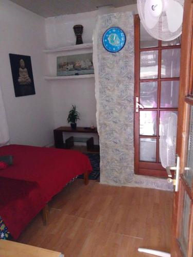 a room with a door with a clock on the wall at La Créole chambres Doubles 2 voyageurs in Saint-Leu