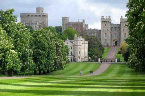 een groot kasteel met een groen gazon ervoor bij Windsor Royal Retreat Luxury 1BED Apartment in Windsor
