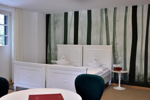 a room with a white bed and green and black stripes at Parkhotel Sole Paradiso in San Candido