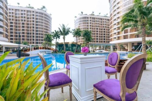 a hotel patio with purple chairs and a pool at Ideal Budget and Cozy Private Studio with Amazing Pool by SYM C738 in Phnom Penh