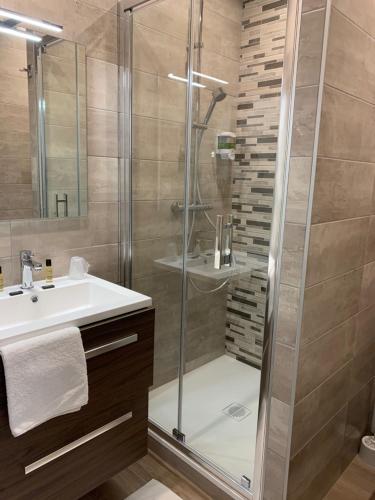 a bathroom with a glass shower and a sink at La Bonbonniere - Sure Hotel Collection by Best Western in Talant