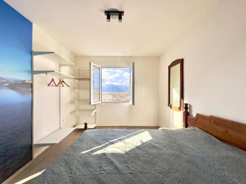 a bedroom with a large window and a large rug at JG Sunny Balcony apartment Skadar Lake in Podgorica