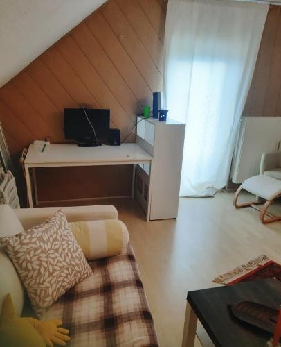 a living room with a couch and a desk in a attic at Rooming Green mit Seeblick in Weyregg